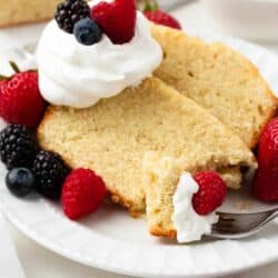 Slice of pound cake with berries and whipped cream on top.