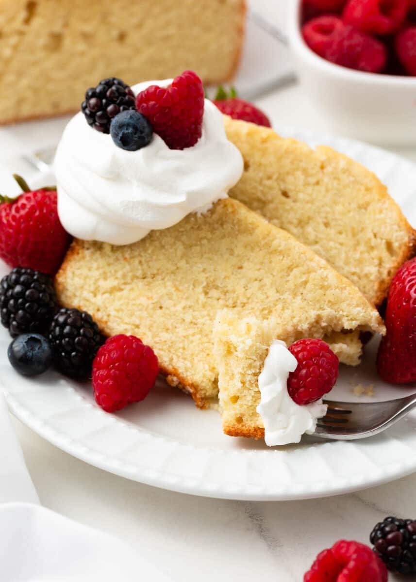 Slice of pound cake with berries and whipped cream on top.