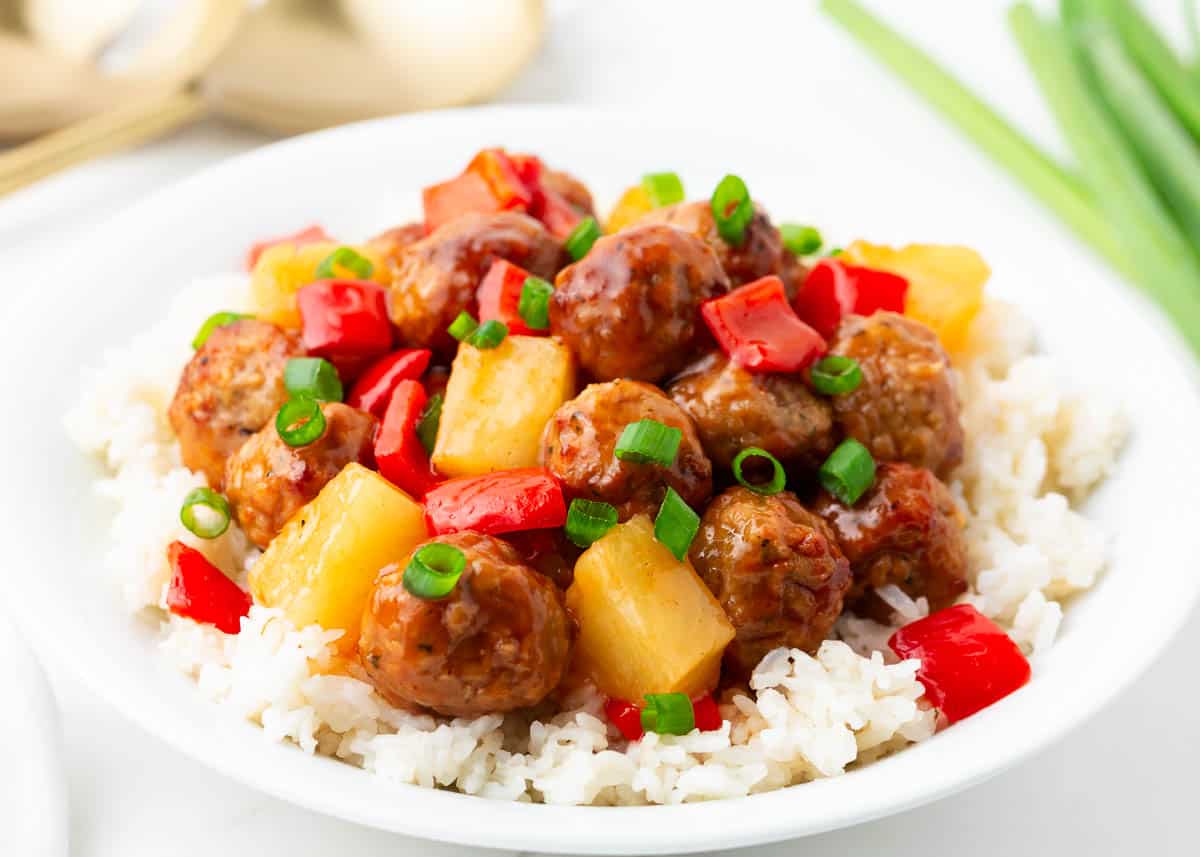 Sweet and sour meatballs and rice in a bowl.