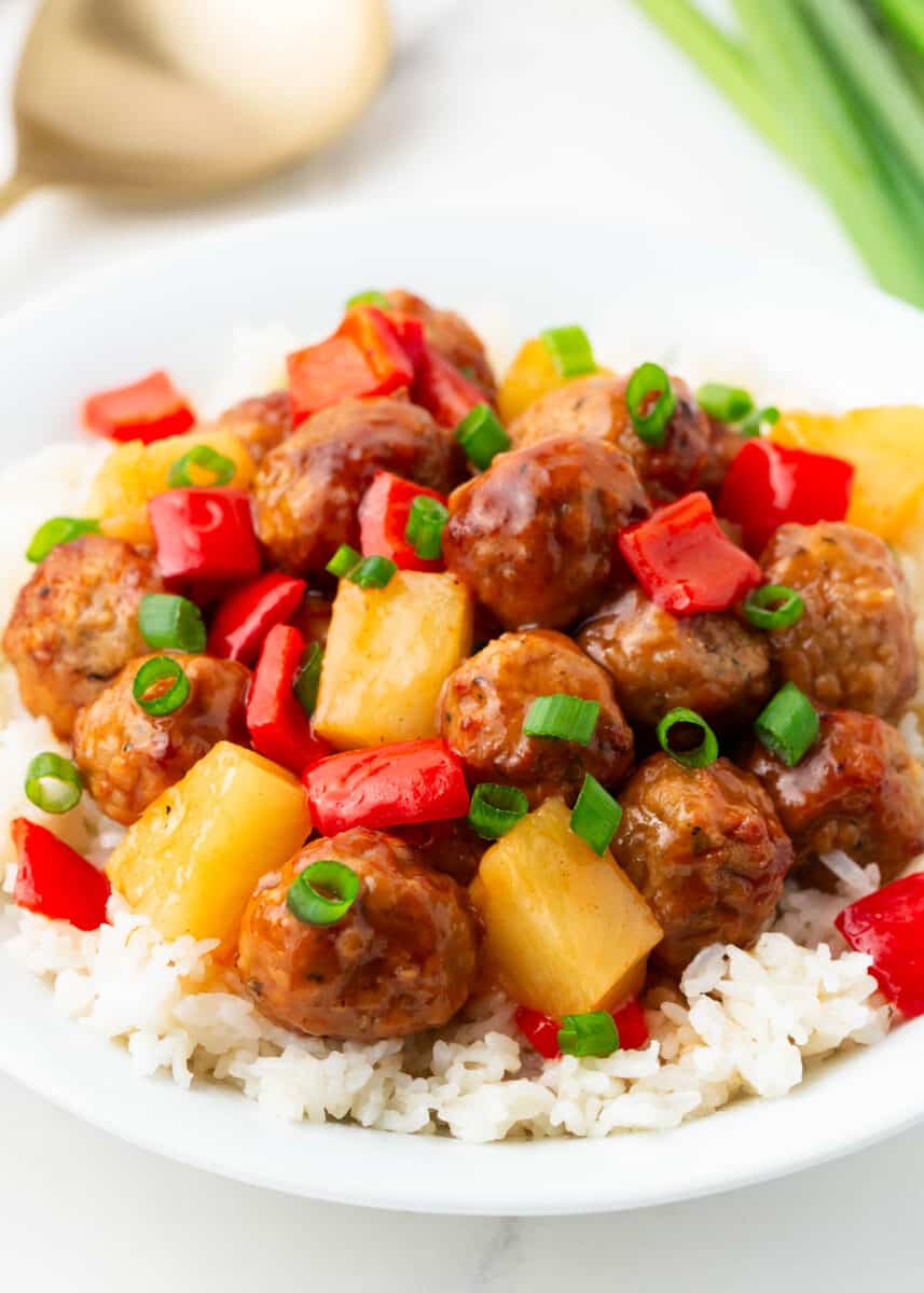 Sweet and sour meatballs and white rice in a bowl.