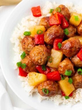 Sweet and sour meatballs and pineapple and rice in a bowl.