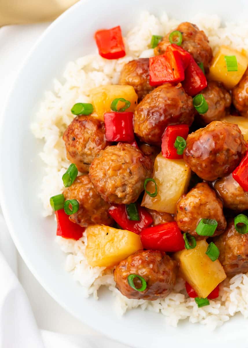 Sweet and sour meatballs and pineapple and rice in a bowl.