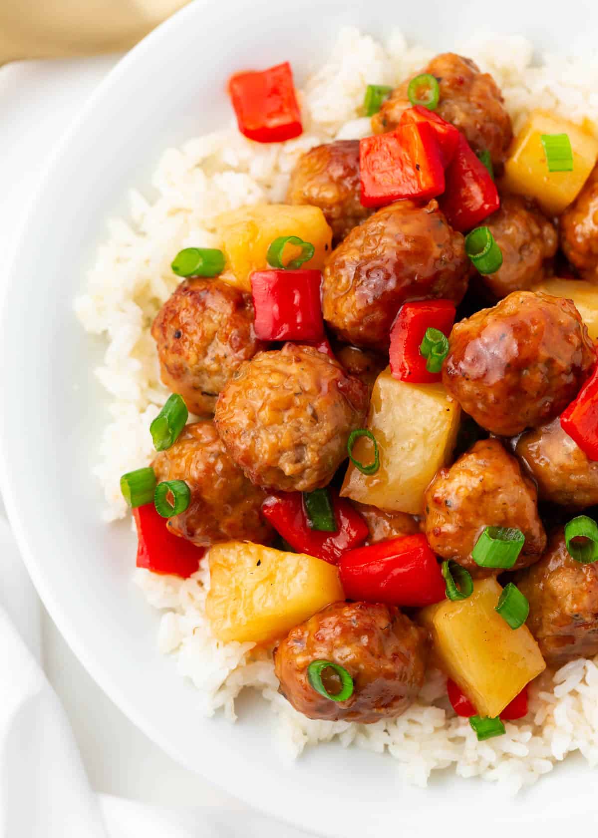 Sweet and sour meatballs and pineapple and rice in a bowl.
