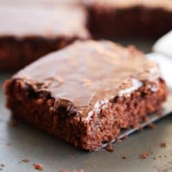 Slice of chocolate Texas sheet cake on baking sheet.