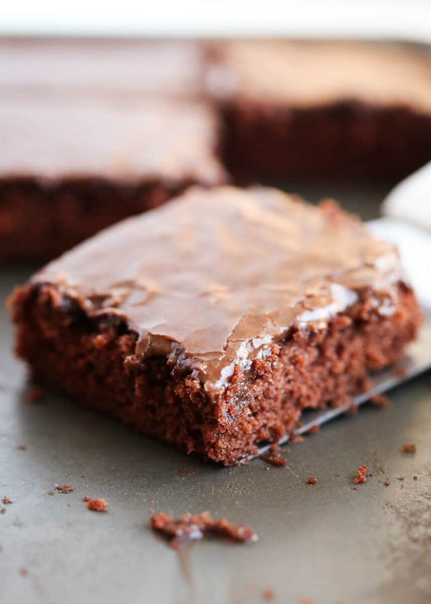 Slice of chocolate Texas sheet cake on baking sheet.