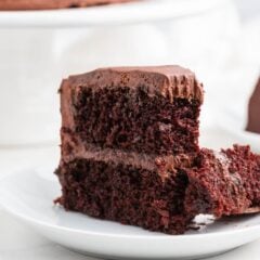 A slice of chocolate cake with fudgy layers and chocolate buttercream.