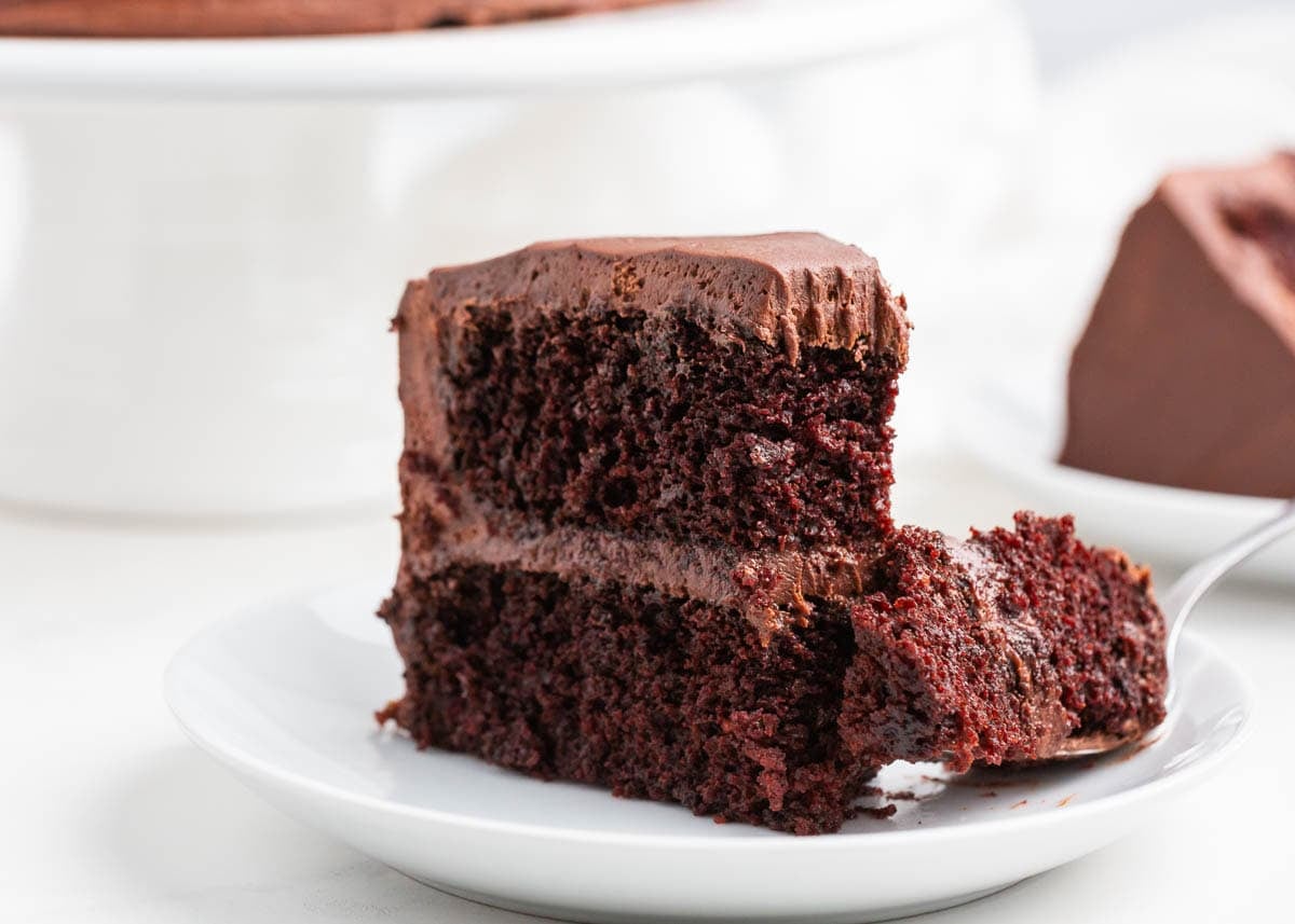 A slice of chocolate cake with fudgy layers and chocolate buttercream.
