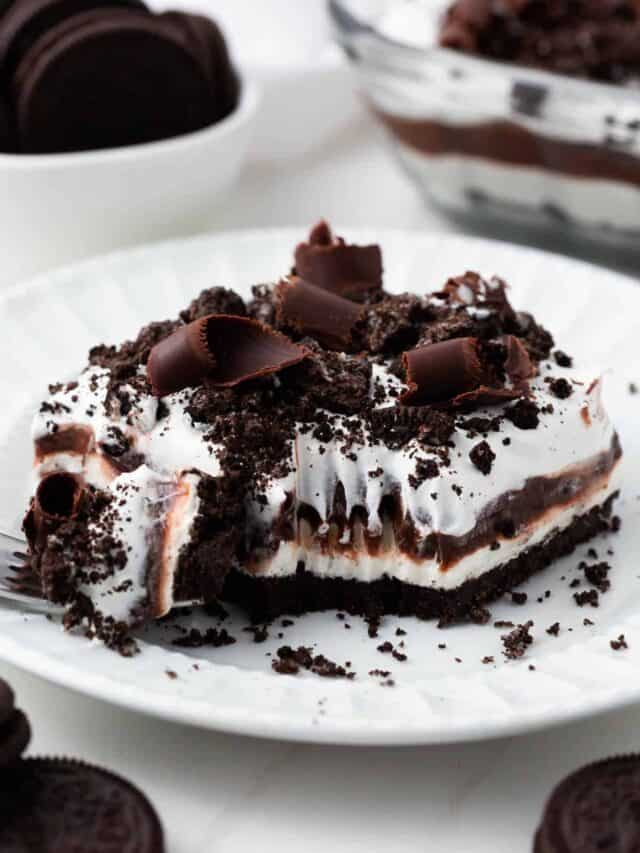 Slice of chocolate lasagna with a fork on a white plate.