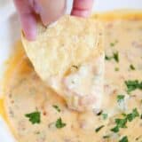 Chip dipping into sausage cream cheese rotel dip.
