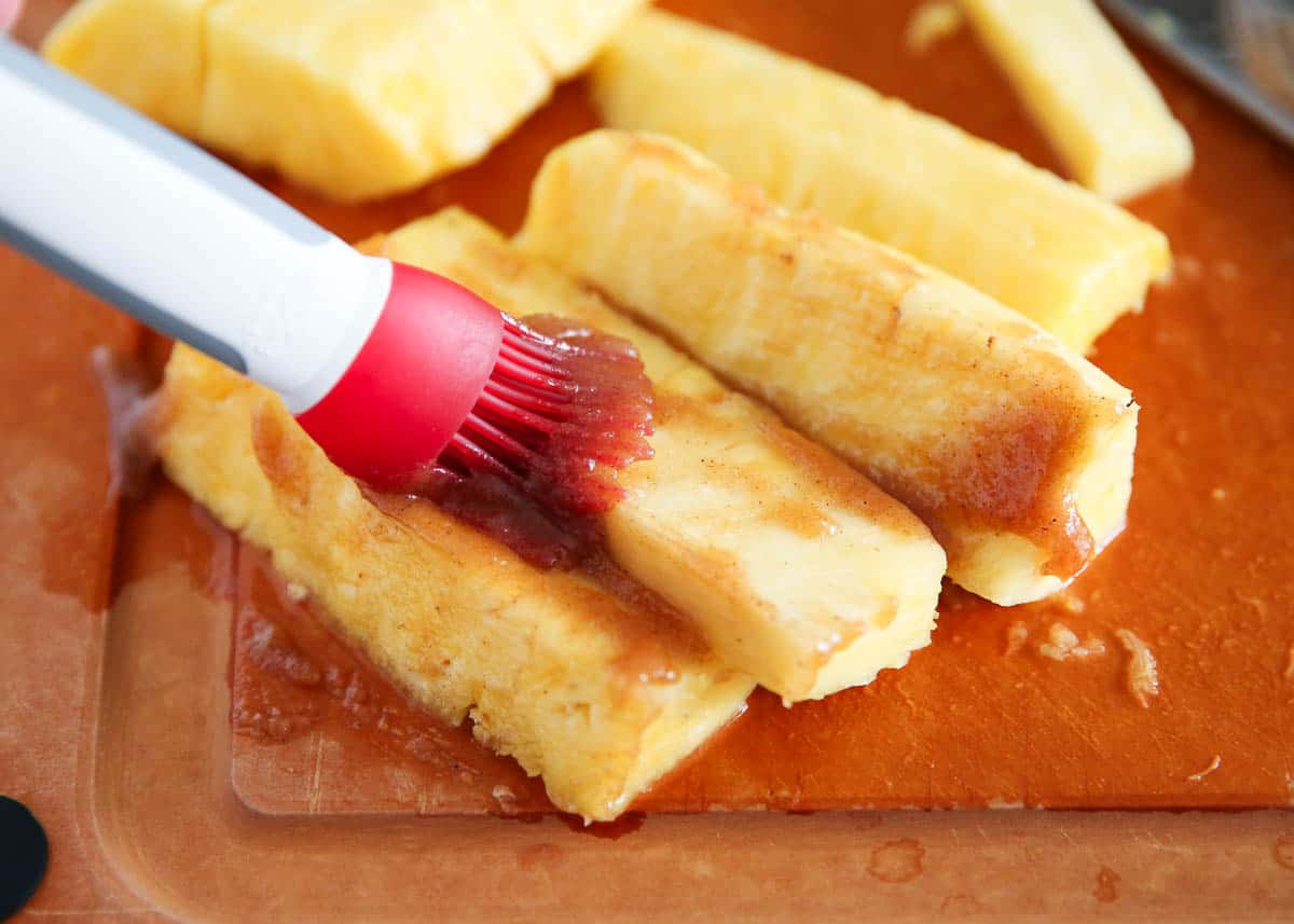 Glaze being brushed onto pineapple.