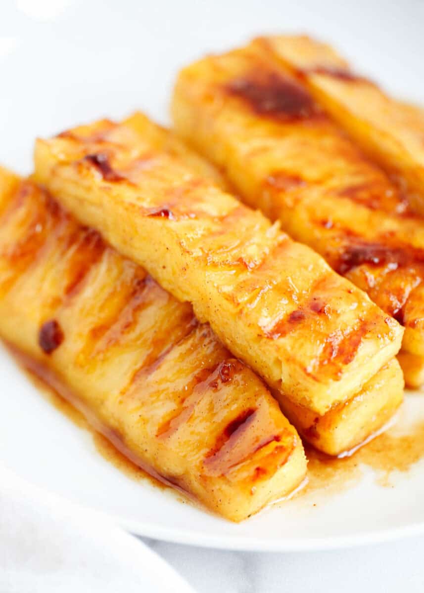 Grilled pineapple on a white plate.