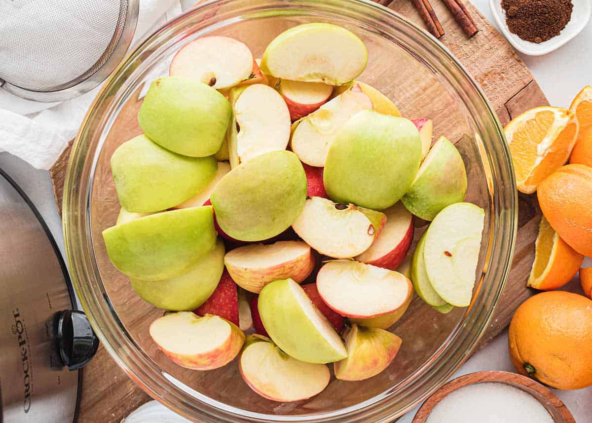 A bowl of apples in a glass bowl on counter.