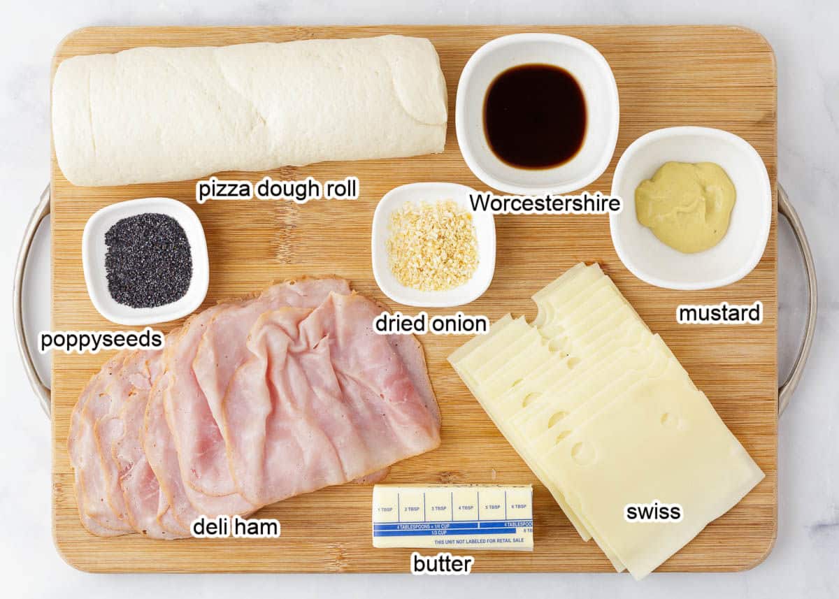 Ham and cheese pinwheel ingredients on a wooden board.