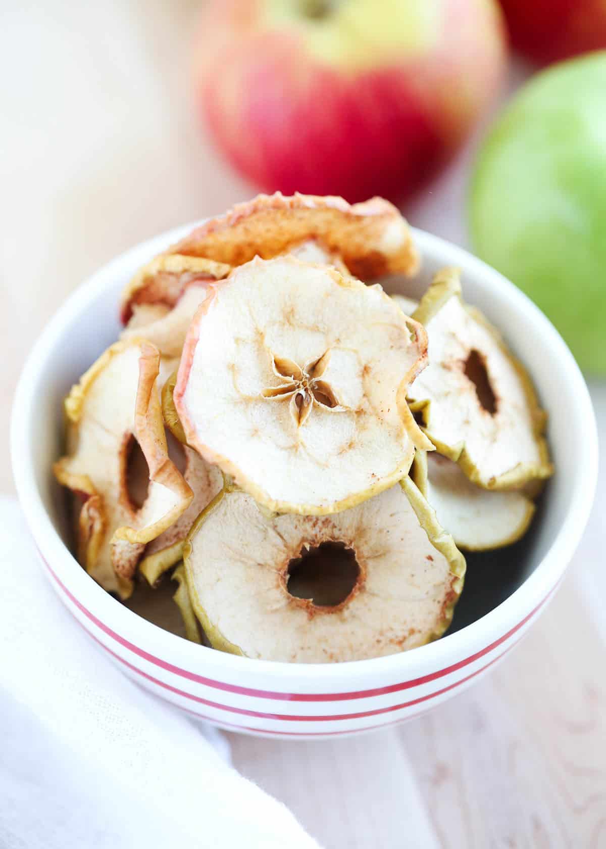 Apple chips in a red and white bowl.