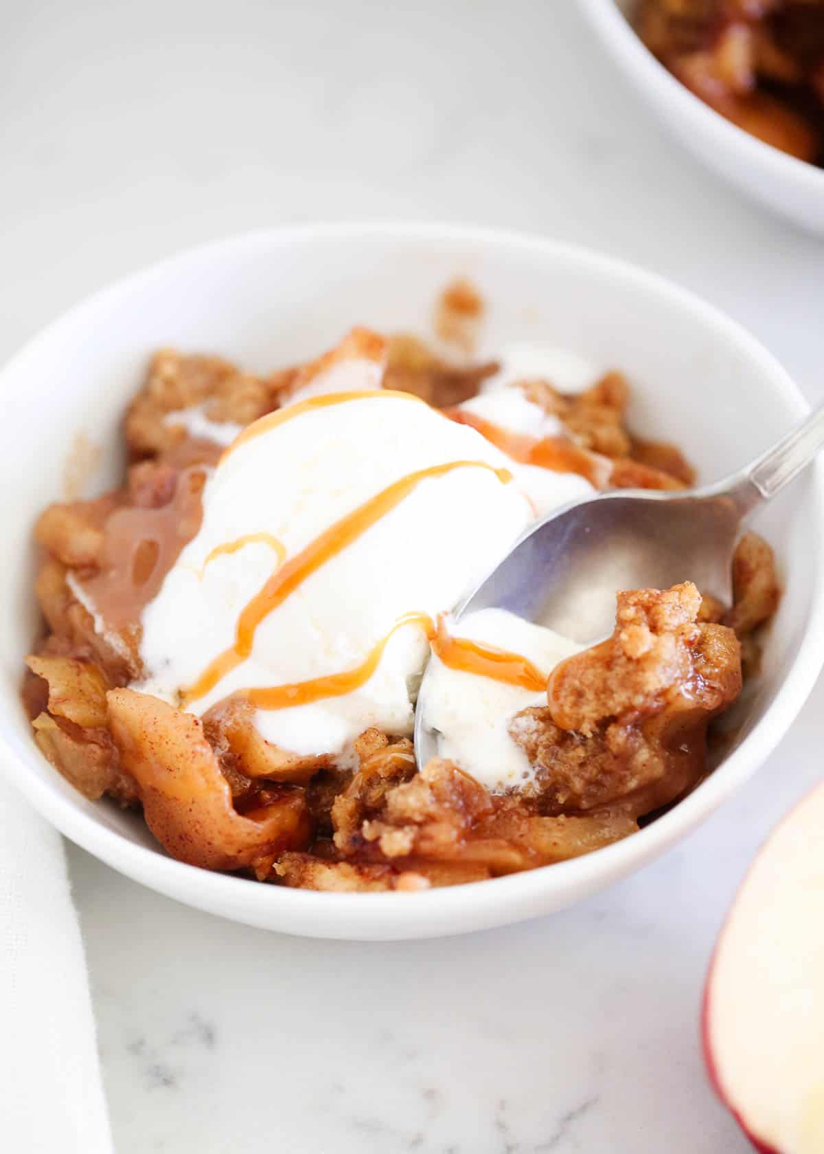 Apple crumble in a bowl with ice cream.