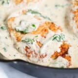 Close up of chicken florentine in a cast iron skillet.