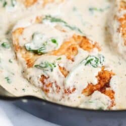 Close up of chicken florentine in a cast iron skillet.