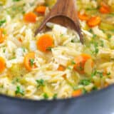 Chicken orzo soup in a black pot.