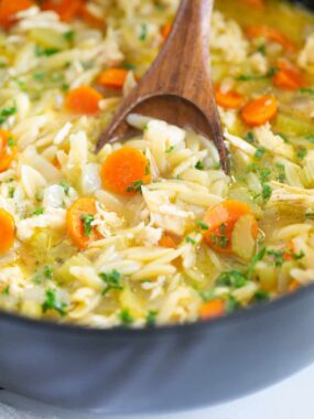 Chicken orzo soup in a black pot.