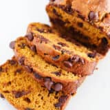 Sliced chocolate chip pumpkin bread on parchment paper.