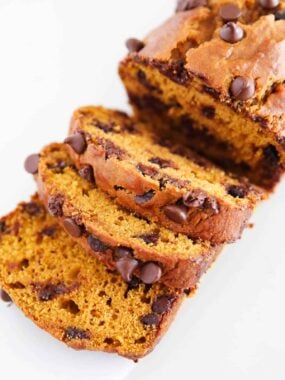 Sliced chocolate chip pumpkin bread on parchment paper.