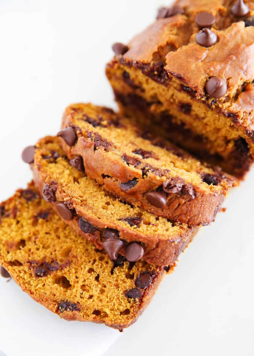 Sliced chocolate chip pumpkin bread on parchment paper.