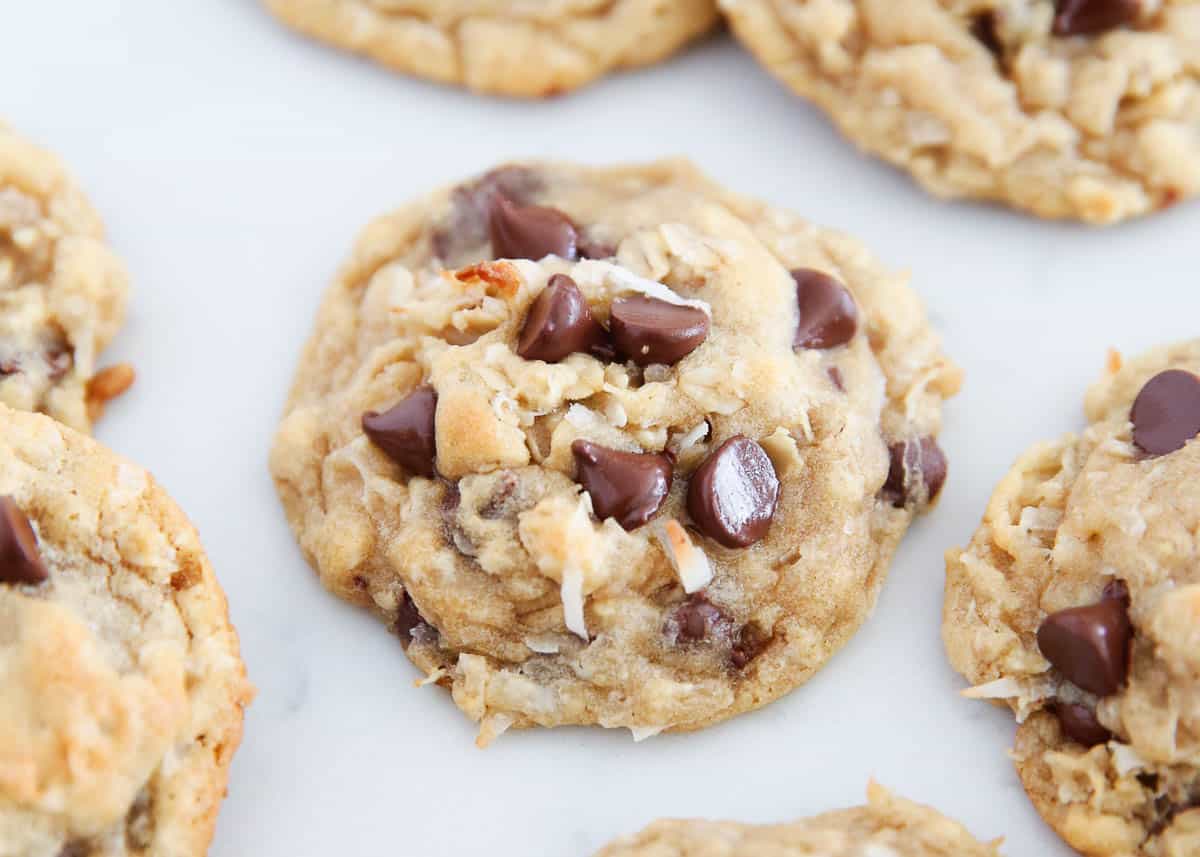 Move over regular chocolate chip cookies, here come delicious chewy coconut chocolate chip cookies to knock your socks off! Bake fresh or freeze the dough for later, these cookies do not disappoint! Coconut chocolate chip cookie on countertop.