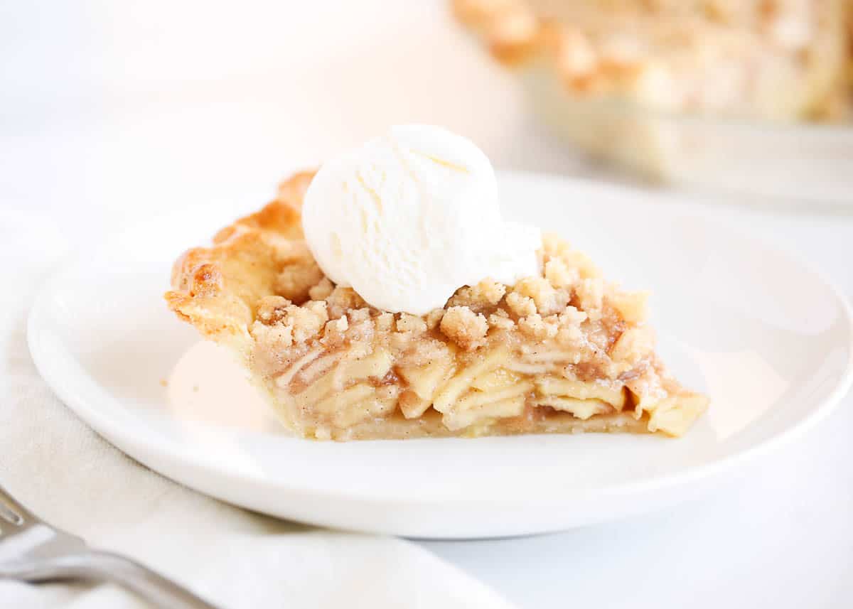 Slice of dutch apple pie on a white plate.