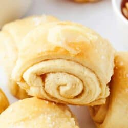 Close up of parker house roll with butter on top.