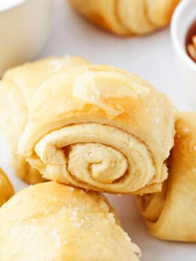 Close up of parker house roll with butter on top.