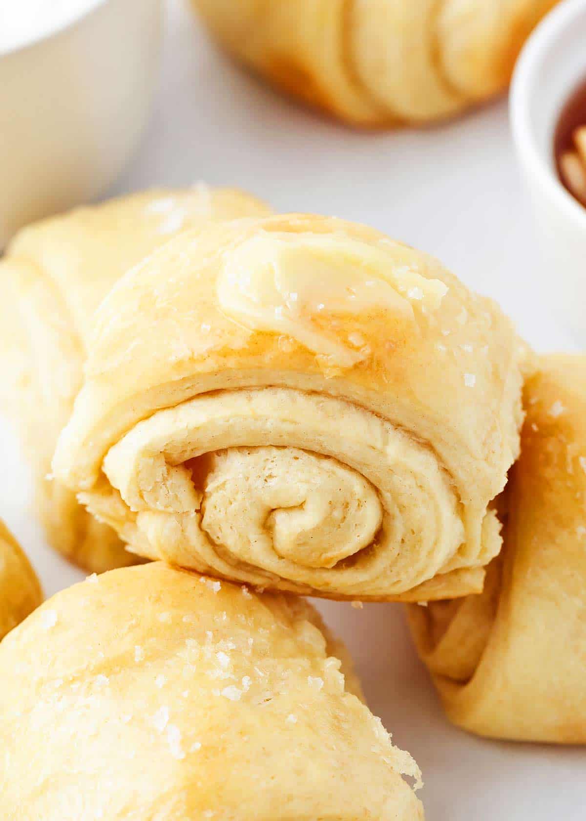 Close up of parker house roll with butter on top.