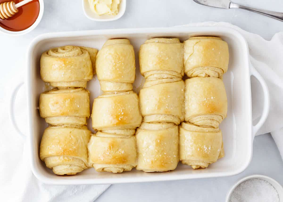 Baked parker house rolls in a white baking dish.