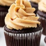 Pipe the peanut butter frosting onto a chocolate cupcake.