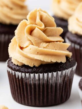Pipe the peanut butter frosting onto a chocolate cupcake.