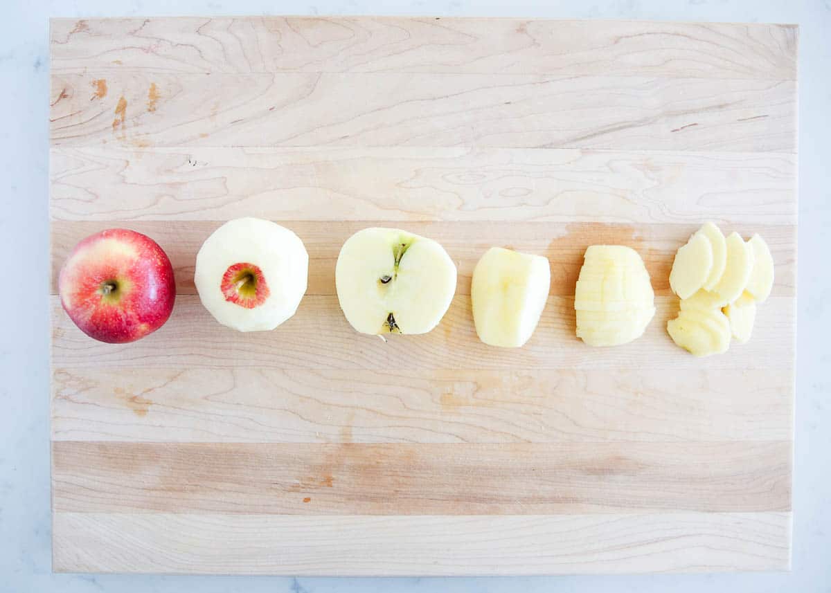 Peeled apples on a wooden cutting board.