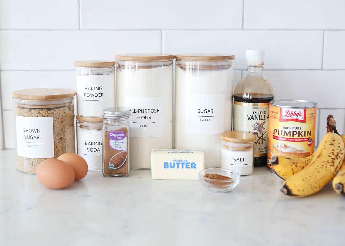 Pumpkin banana bread ingredients on marble countertop.