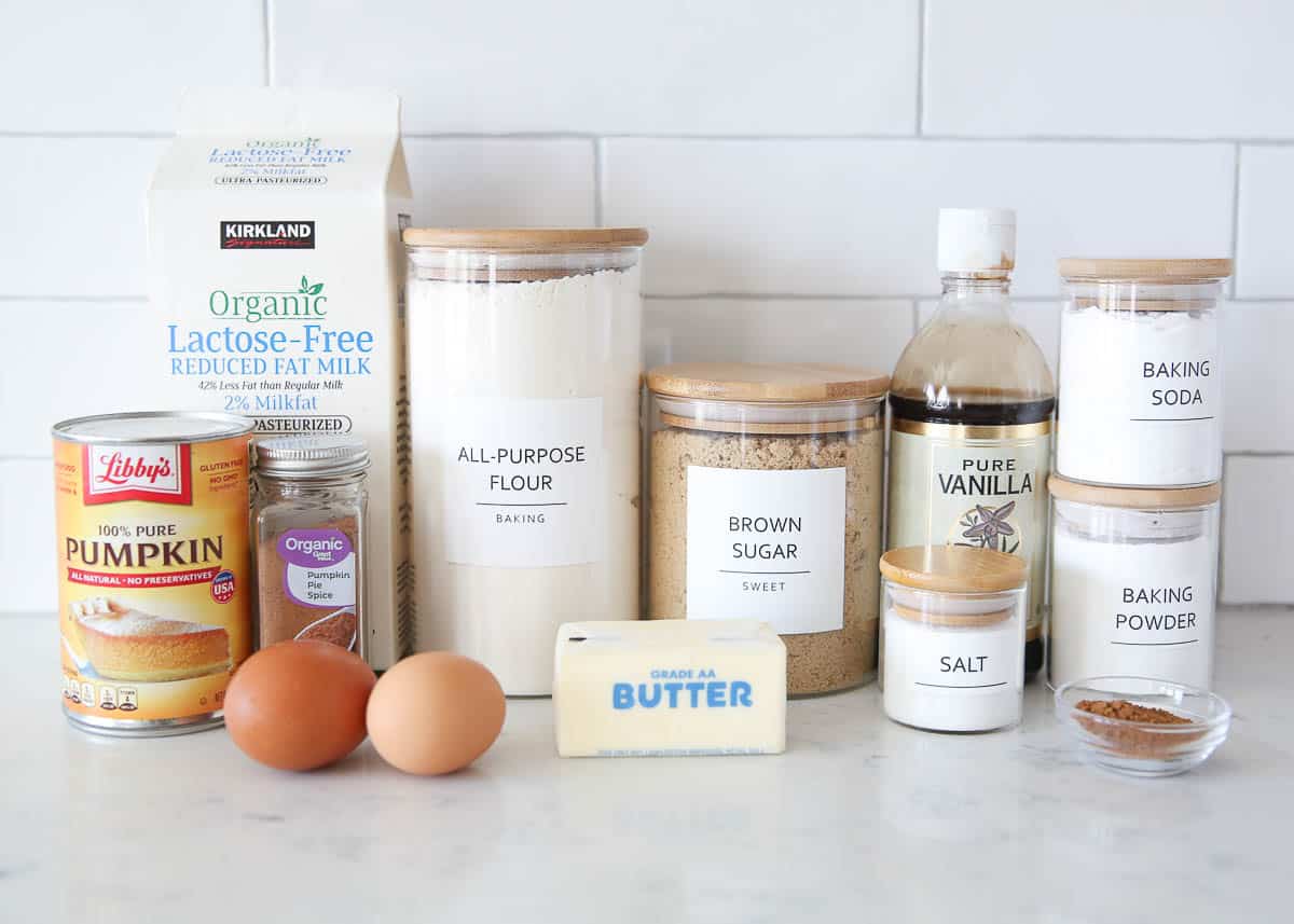 Pumpkin pancake ingredients on marble countertop.