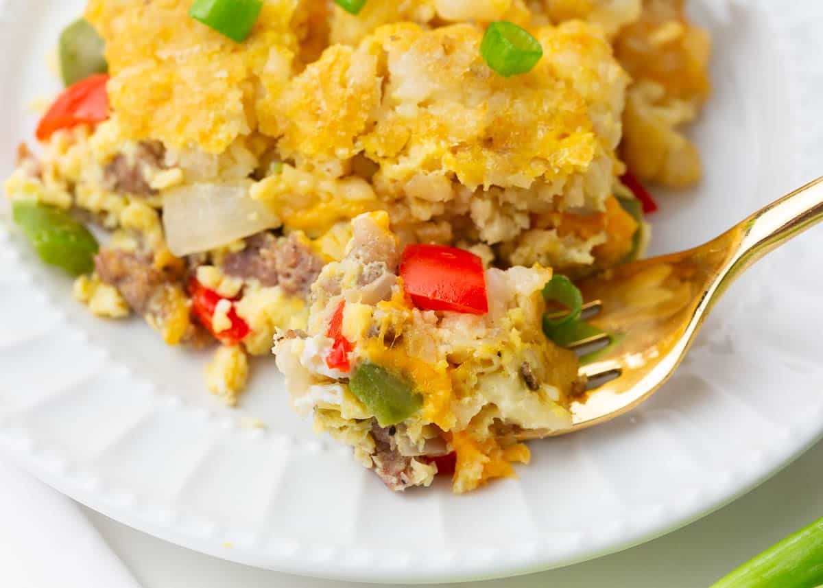 Fork taking a bit of tater tot breakfast casserole.