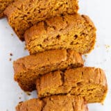 Sliced pumpkin banana bread on parchment paper.