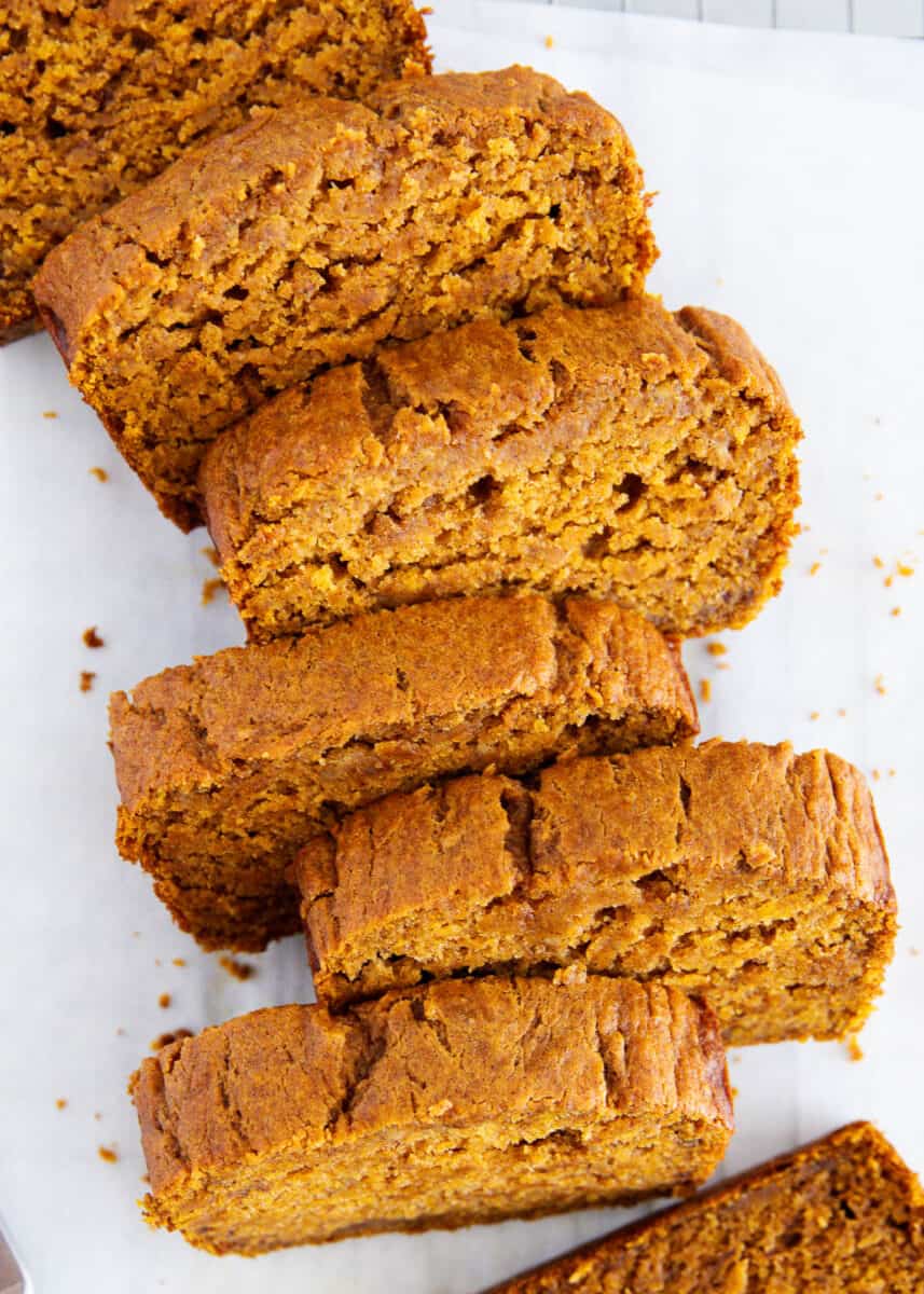 Sliced pumpkin banana bread on parchment paper.