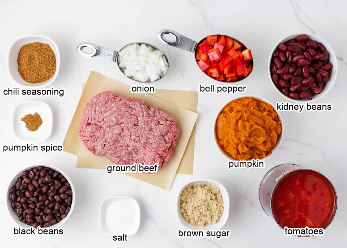 Pumpkin chili ingredients on marble countertop.