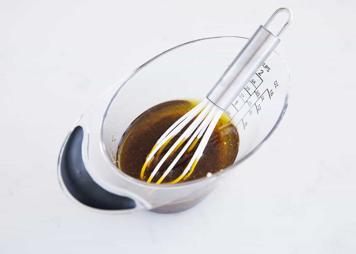Whisking balsamic dressing in measuring cup.