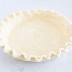 All-butter pie crust in a pie dish ready to bake.
