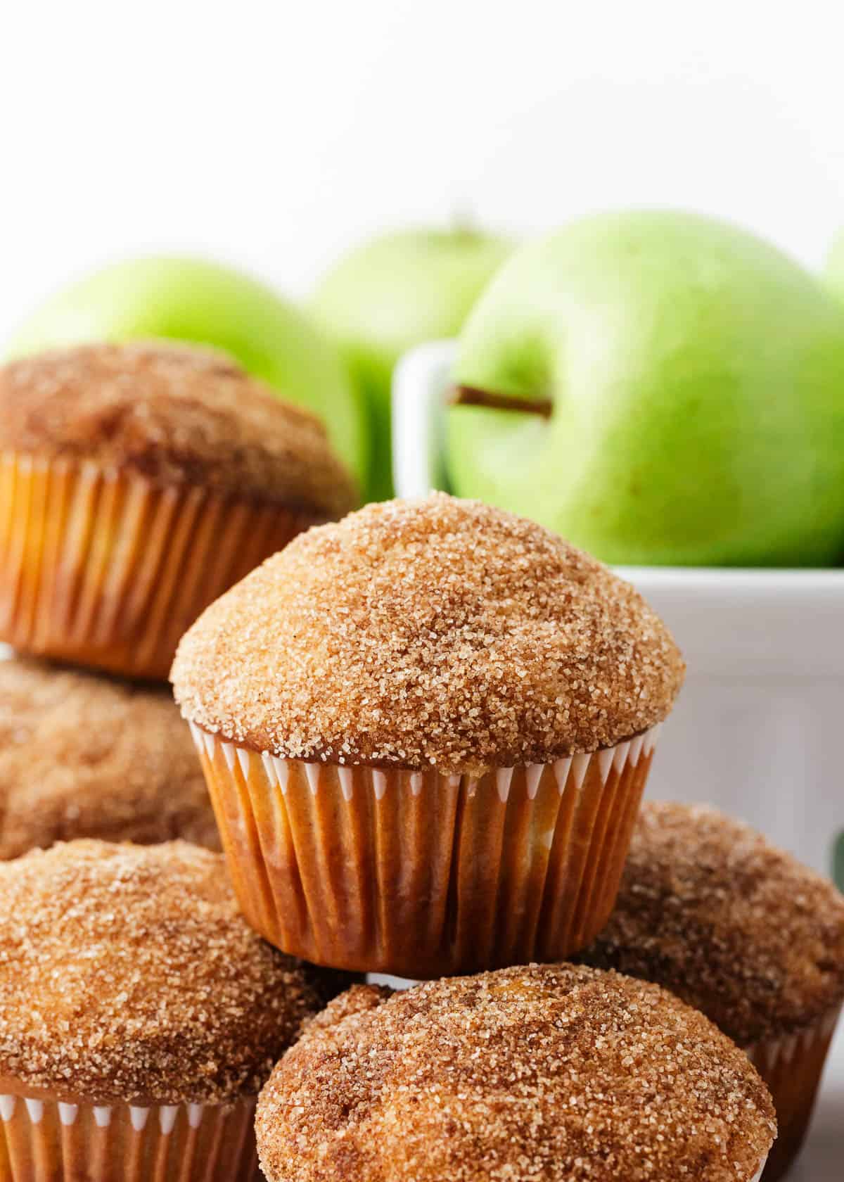 Stacked apple muffins on a counter.