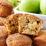 Apple muffin cut in half stacked on top of muffins.