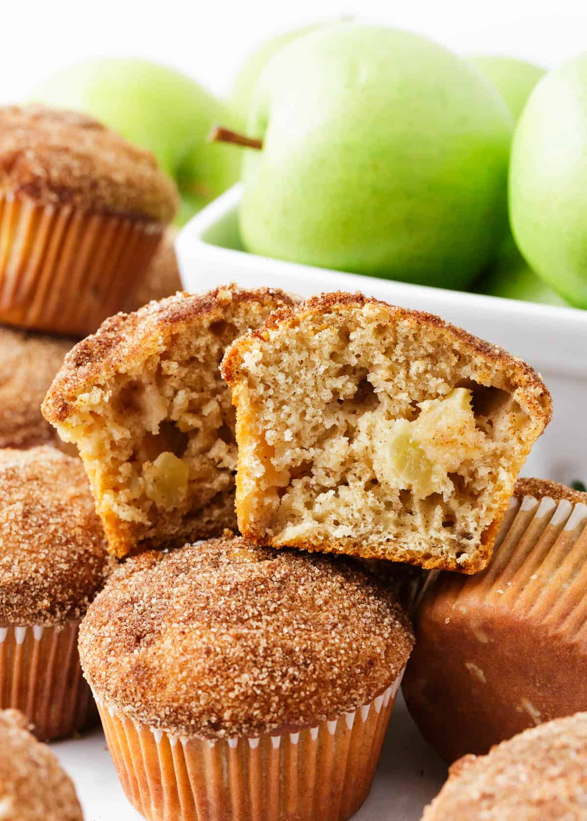 Apple muffin cut in half stacked on top of muffins.