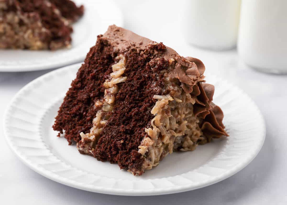 Slice of German chocolate cake on white plate.