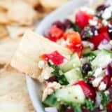 Dipping a pita chip into feta dip.