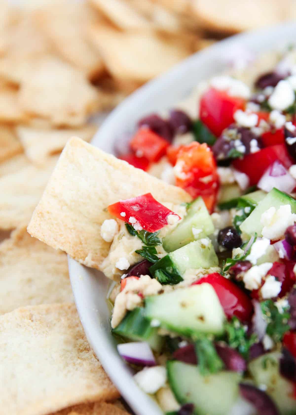 Dipping a pita chip into feta dip.