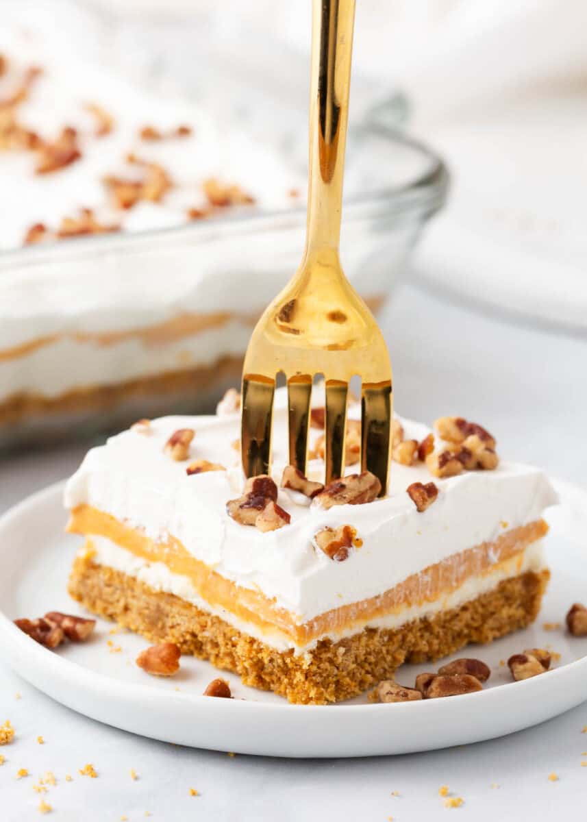 Pumpkin lasagna on a white plate with a gold fork.
